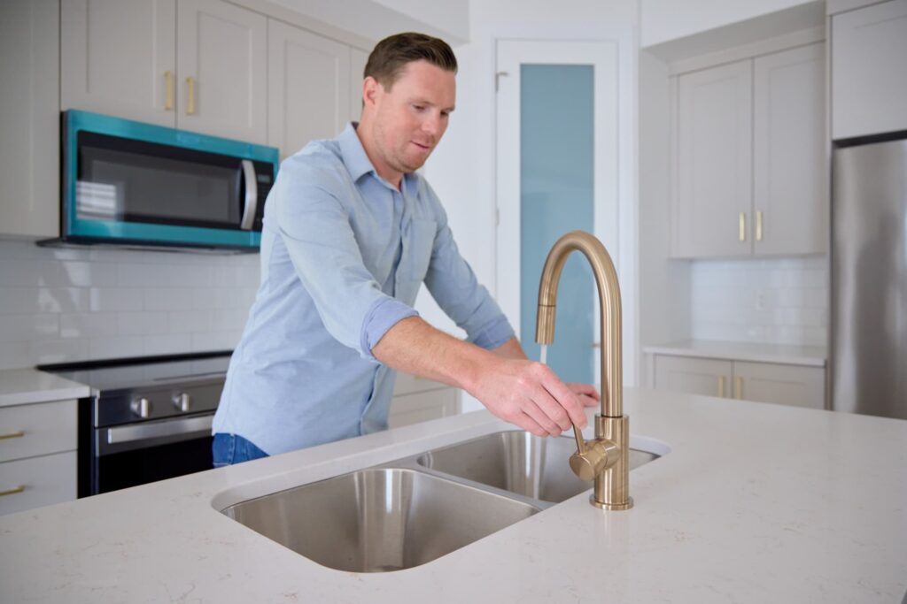 Man testing kitchen tap