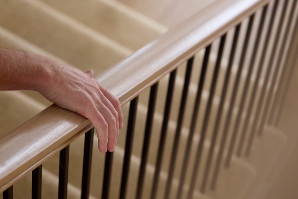 hand holding on to bannister 
