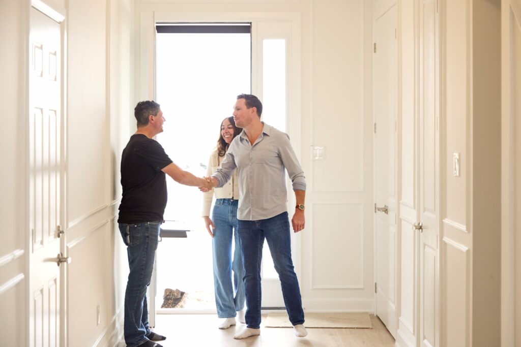 couple entering a new home and shaking hands with glenview associate