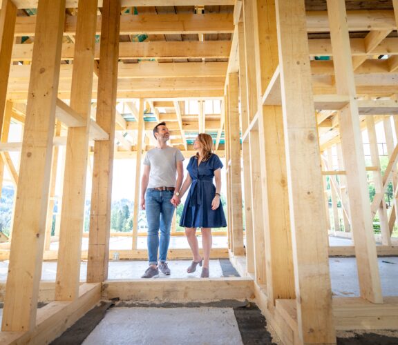 A couple standing in their new home, pre-drywall