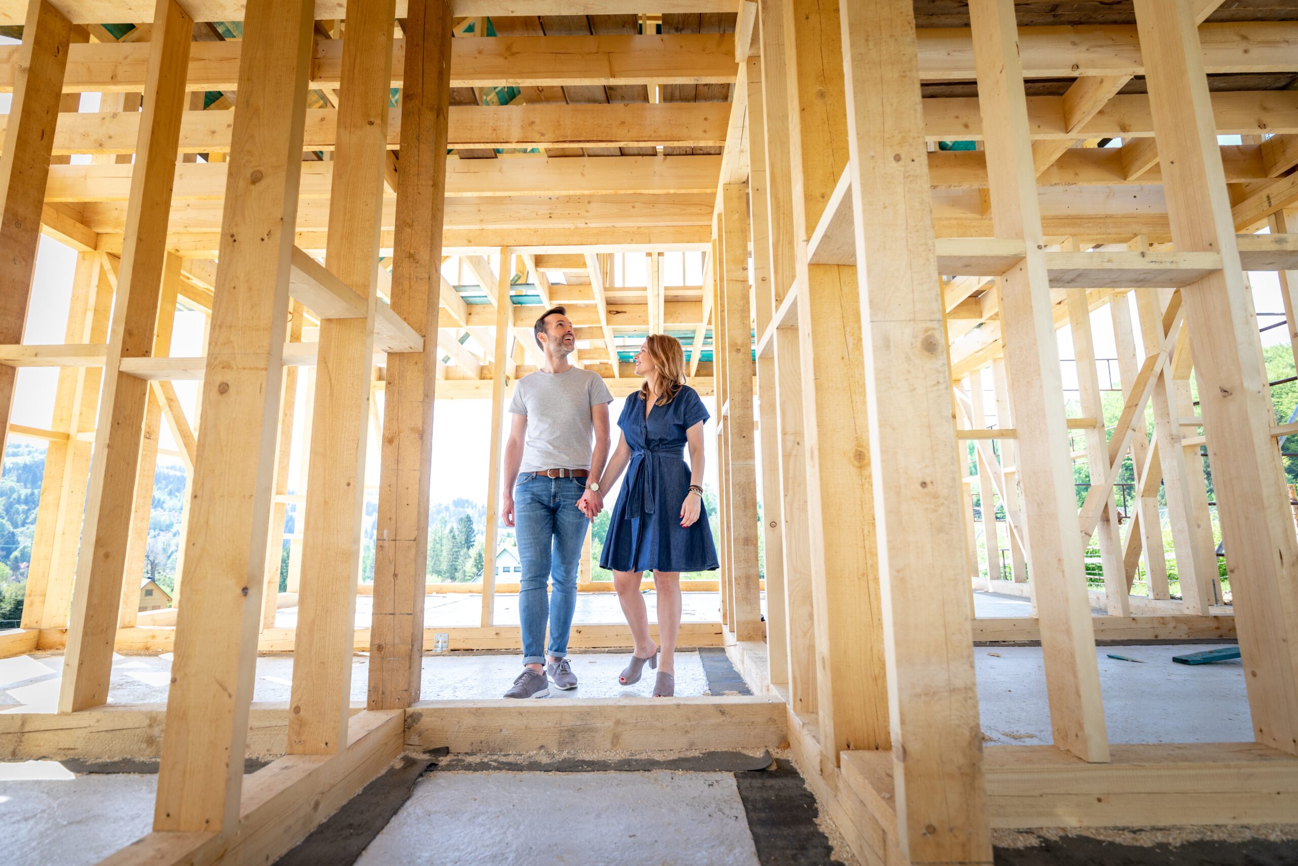 A couple standing in their new home, pre-drywall