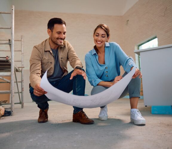 Happy couple looking at plans for their new home