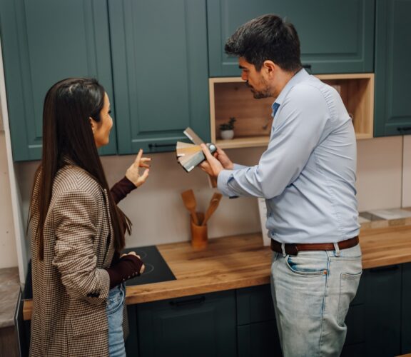 Couple standing in front of kitchen cabinet display picking colours