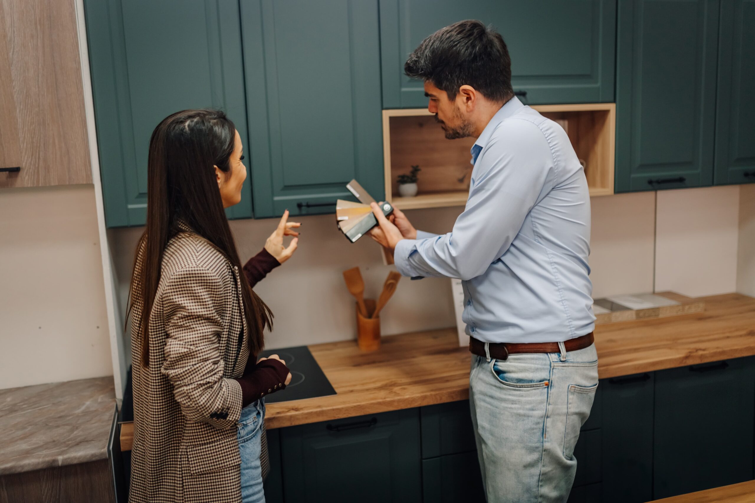 Couple standing in front of kitchen cabinet display picking colours